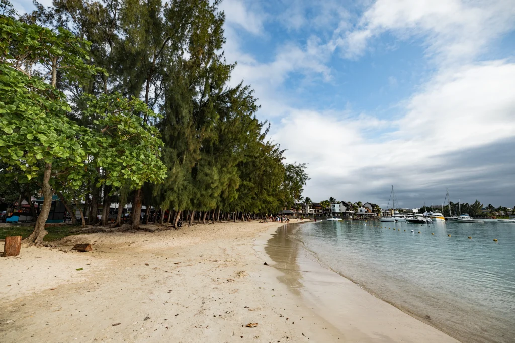 Boats anchored in the shallow, turquoise waters of Grand Baie, a top answer for what beaches can i visit in mauritius for a lively atmosphere