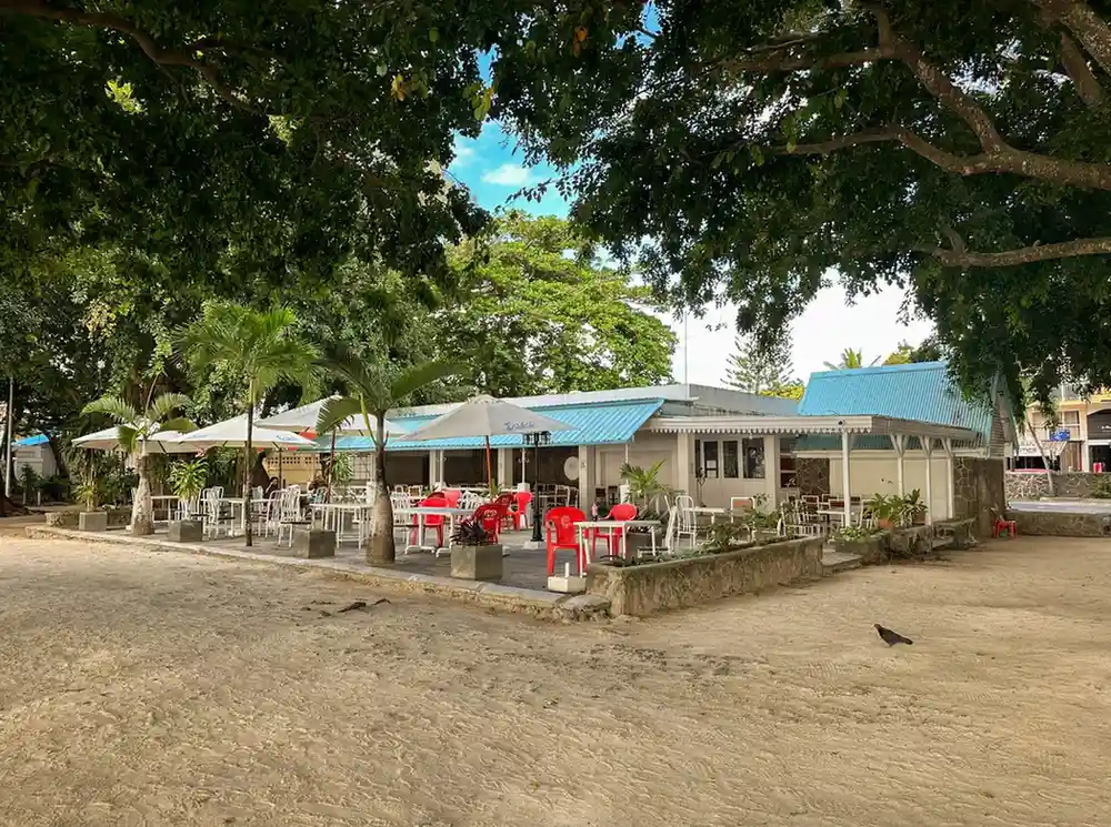 Outdoor dining area at a guest house in North Mauritius surrounded by tropical trees