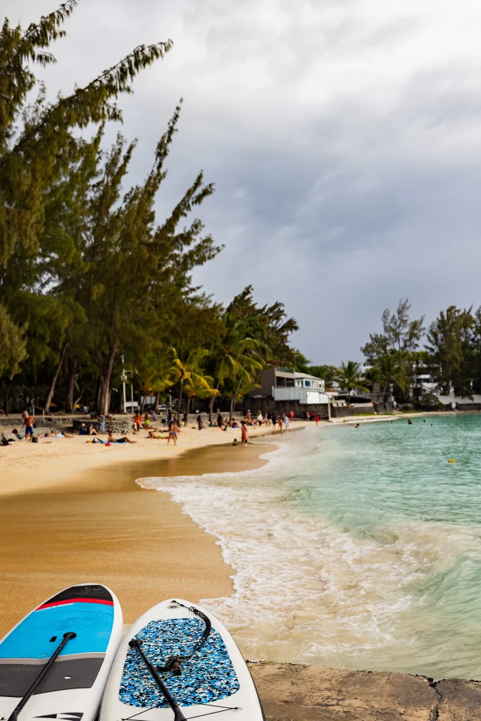 Beach near Grand Baie in North Mauritius with turquoise water and paddleboards on the shore