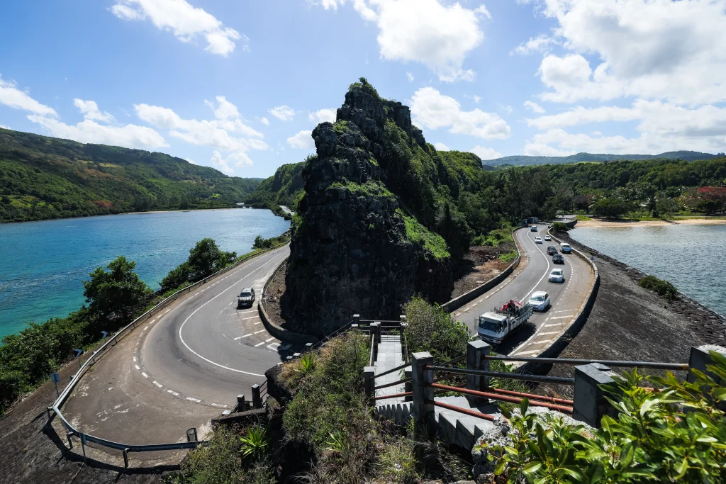 Scenic coastal road in South Mauritius with winding drive around volcanic rock formation and turquoise lagoon views